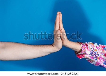 Photo of two mature young people arms palms high five hello greeting isolated blue color background