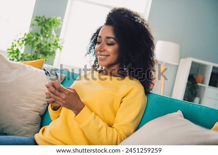 Photo of lovely cute pretty girl sitting on sofa enjoying weekend chatting in cozy modern apartment