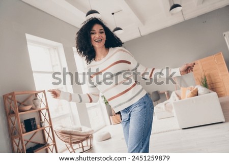 Photo of adorable carefree lady dressed striped pullover having fun indoors apartment room
