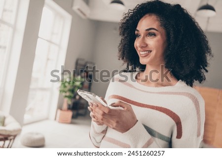 Photo of dreamy cheerful lady dressed striped pullover communicating apple iphone samsung gadget indoors apartment room