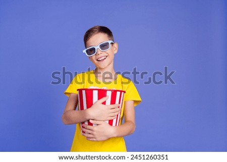 Photo of cheerful adorable boy wear stylish yellow clothes hold basket popcorn watch cinema isolated on purple color background