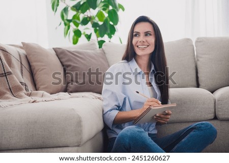 Photo of nice lady sit floor hold notepad think wear blue shirt bright interior flat indoors