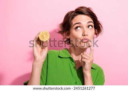 Photo portrait of attractive woman hold half lemon look interested empty space wear trendy green clothes isolated on pink color background Royalty-Free Stock Photo #2451261277