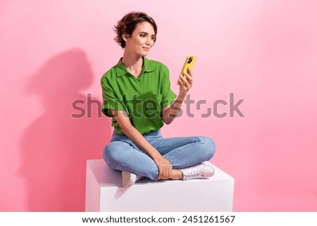 Full length photo of gorgeous nice person sit podium use smart phone empty space isolated on pink color background