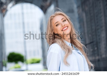 Photo of positive pretty charming girl enjoying walk in new city spring sunny day on blurred backdrop
