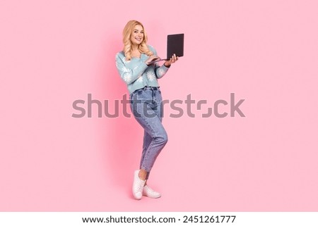 Full size photo of lovely young woman hold netbook eshopping dressed stylish flower print garment isolated on pink color background
