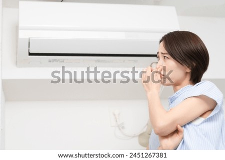 Lifestyle image of a young woman who is concerned about the smell of the air conditioner