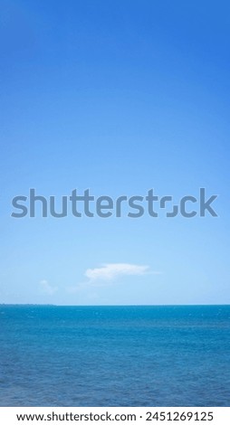 blue sea and sky with white clouds in the middle with a 3:1 composition