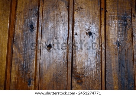 The wall is made of birch paneling and painted with colored brown varnish and colorless oil varnish. (Over time, the colorless coating fell off the panels). Royalty-Free Stock Photo #2451274771