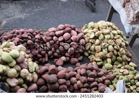 Assortment of Fresh Organic Cola Nuts in Various Colors Displayed on a Tray at an African Market