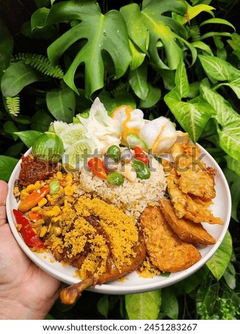 Indonesian Food. known as "Nasi Liwet" with stir-fried corn, fried chicken, fried tempeh, fried bakwan, petai and other vegetables.