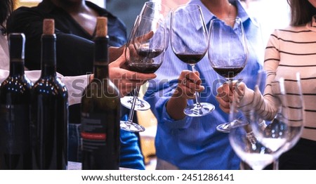 Close up group of women holding glass of wines celebrating friendship 