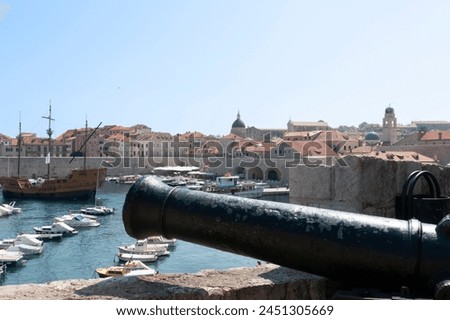 Ancient cannon points out across Dubrovnik habour from within walls of ancient city in Croatia.