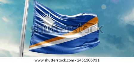 Marshall Islands national flag waving in beautiful sky.