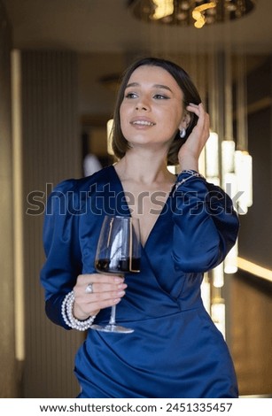 beautiful woman in restaurant drinking cocktail at bar countertop or eating sweet desert,hot napoleon.girl in night dress with glass of wine in hand.restaurant business advertising photography