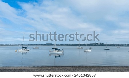 At dawn, this picture shows a quiet bay, and the anchored sailboat is quietly moored under the blue sky