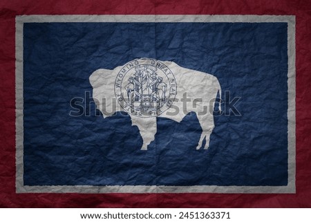colorful big national flag of wyoming state on a grunge old paper texture background