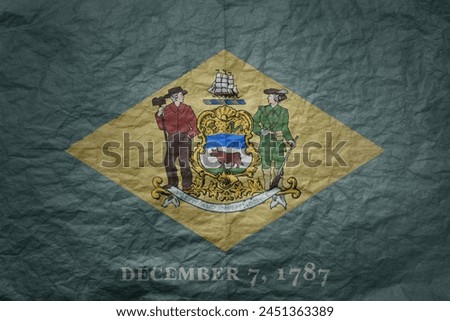 colorful big national flag of delaware state on a grunge old paper texture background