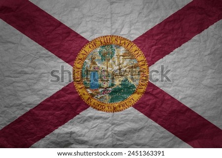 colorful big national flag of florida state on a grunge old paper texture background