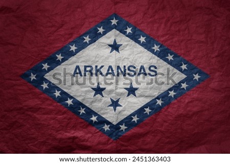 colorful big national flag of arkansas state on a grunge old paper texture background