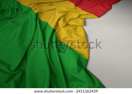 waving colorful national flag of mali on a gray background.