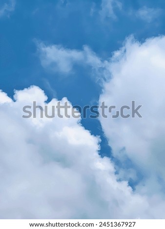a photography of a plane flying through a cloudy blue sky.
