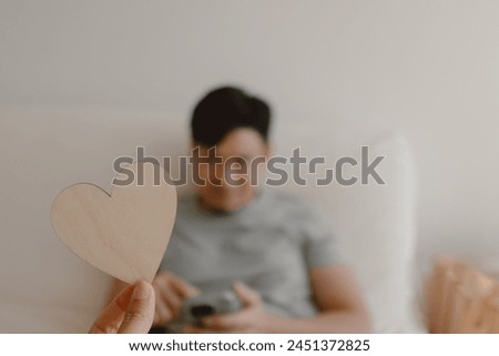 Photo of woman hand holding wooden empty space of heart design, showing and giving to asian man, showing love gesture, lovely couple marriage, valentines concept.