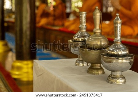 Water gravels sit on a table and monks are chanting. Royalty-Free Stock Photo #2451373417