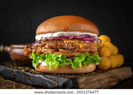 Gourmet chicken burger with cheese and veggies. Juicy delicious hamburger on darkmood picture for restaurant decoration, poster. 