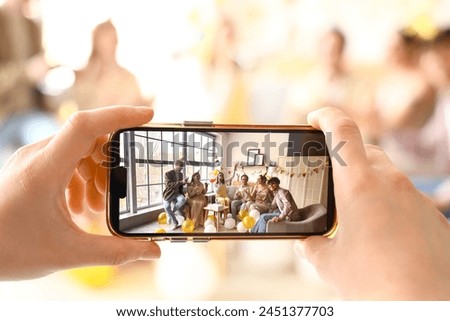 Young woman taking picture of her friends celebrating Birthday at home, closeup