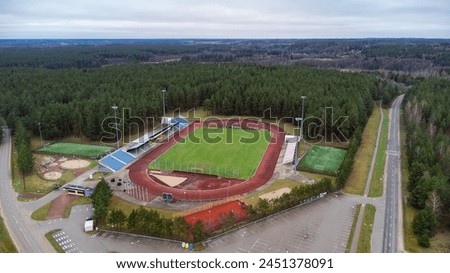 Soccer city stadium located in a pine forest, drone view. High quality photo