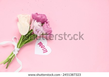 Card with word MOM and beautiful tulips on pink background. Mother's Day celebration