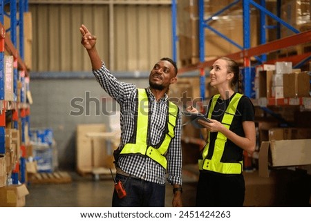 Retail Warehouse full of Shelves with Goods in Cardboard Boxes, Male and Female Supervisors Use Digital Tablet and Look For a Right Shelf. Forklift Working in Logistics Storehouse