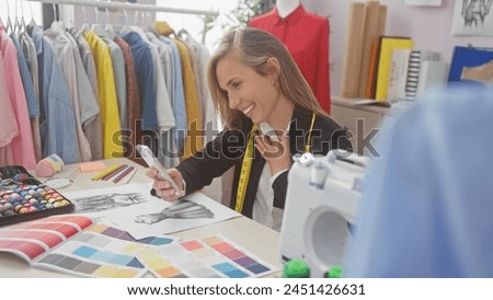 Smiling woman using smartphone in a colorful fashion design studio with fabric and sewing machine