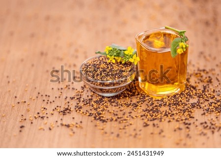 Mustard seeds and oil with mustard flower Royalty-Free Stock Photo #2451431949