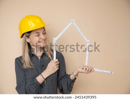 woman, architect, technician, builder, polisher with yellow safety hat and yellow folding rule in front of brown background Royalty-Free Stock Photo #2451439395