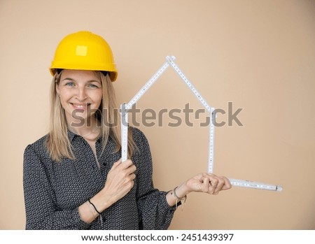 woman, architect, technician, builder, polisher with yellow safety hat and yellow folding rule in front of brown background Royalty-Free Stock Photo #2451439397