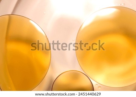 Picture of oil on the surface of the water, golden color, similar to serum for skin care.
