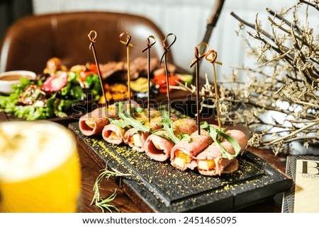 A wooden table is filled with a generous assortment of delicious food, creating a sumptuous feast. Royalty-Free Stock Photo #2451465095
