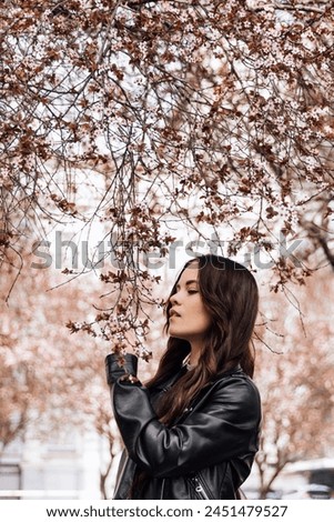 Young beautiful girl is photographed outdoors in flowering tree