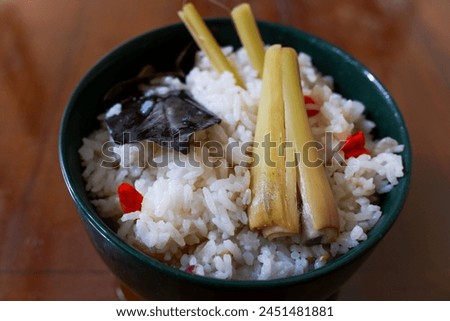 A bowl of Sundanese liwet rice with spices, in the wood table, traditional Indonesian food, stock photo.