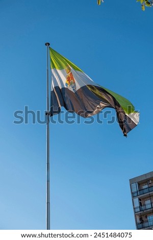 Flag of Extremadura rise waving to the wind with sky in the background