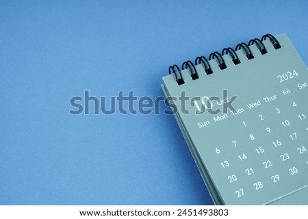 October 2024 desk calendar on blue color background. Copy space.