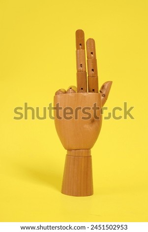 Hand of mannequin with multiple poses isolated on yellow background. Symbol, Puppet.