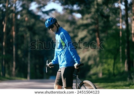 Cyclist rides through the park on a summer day.