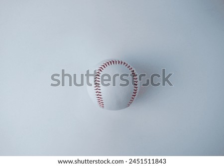 White and red colored baseball sport ball object photography isolated on horizontal white studio background from top angle.