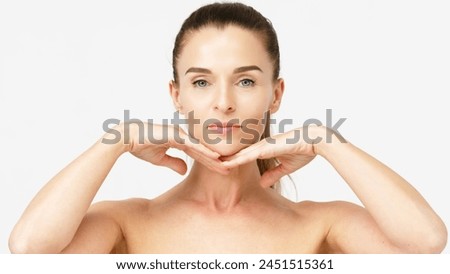 Gorgeous middle aged woman touching her perfect skin. Beautiful portrait of a 40-50 year old woman advertising anti-aging facial products, salon care, skin tightening, isolated on white background. Royalty-Free Stock Photo #2451515361