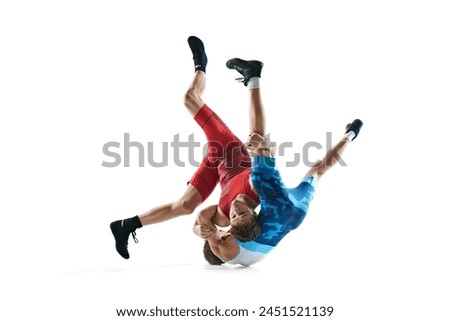 Wrestlers in action, young male competitors in motion, wrestling in, fighting isolated on white background. Concept of combat sport, martial arts, competition, tournament, athleticism