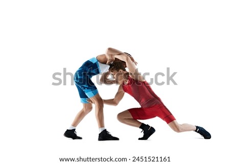Wrestlers in dynamic motion, wrestling, training, showing strength and skills in competitive match isolated on white background. Combat sport, martial arts, competition, tournament, athleticism