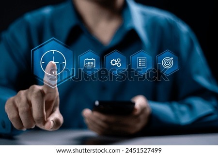 Time management concept. Businessman using smartphone with time management icon on virtual screen. Work planning for increases efficiency and reduces work time. Business project planning.